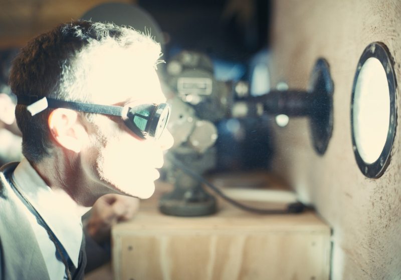 In a film shot still, actor Cillian Murphy as J. Robert Oppenheimer watches a bomb blast.