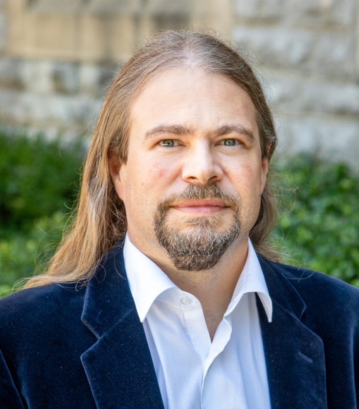 Patrick Huber stands in front of stone wall