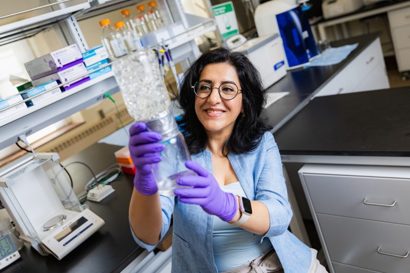 Rana Ashkar holds up a jar full of liquid