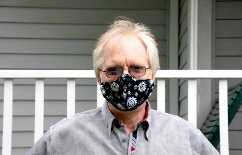 Uwe Täuber of the Department of Physics poses at his house, wearing a mask for COVID safety protocols. 