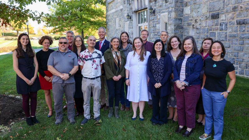Group shot in front of Hokie stone building on a beautiful fall day.
