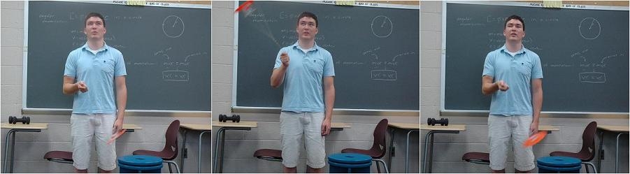 Julian showing centripetal acceleration in front of a blackboard